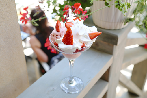 A mouthwatering dessert sundae featuring a combination of fresh strawberries and fluffy whipped cream.