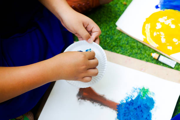Male Thai student's hand painting with fingers