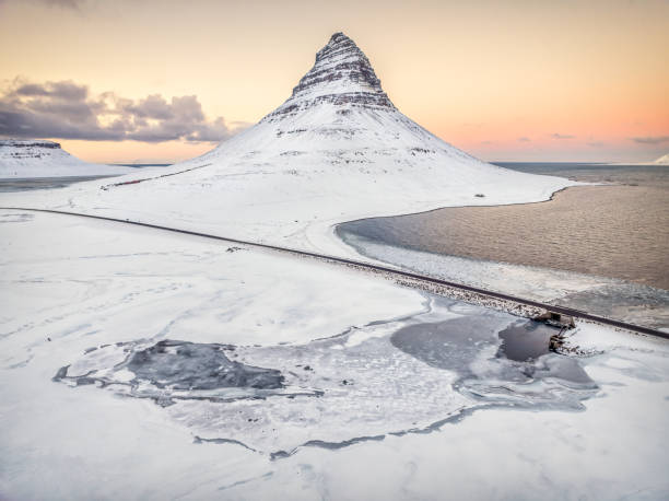 Beautiful sunset at Mount Kirkjufell on the Snaefellsnes Peninsula in West Iceland. From this aerial shot you can see beautiful pastel colours and the coastline around Mt. Kirkjufell