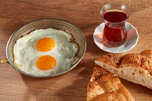 Cheese Plate, tomatoes, jam, and bread over tableFried Eggs And Tea Over Table