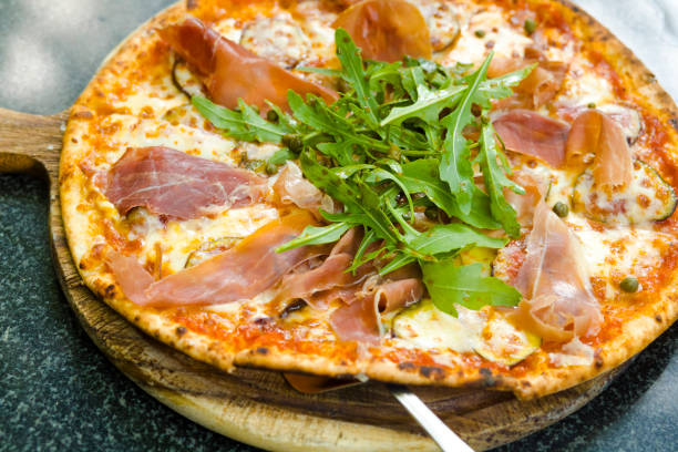 istock Close-up of bacon pizza with lettuce and fig fruit 2117648045