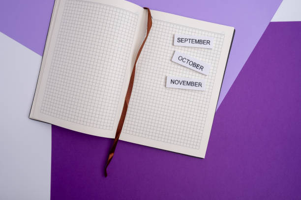 istock September, October, November - reminder of the coming month in a notepad on the table with empty space for text. Layout or template 2117663539