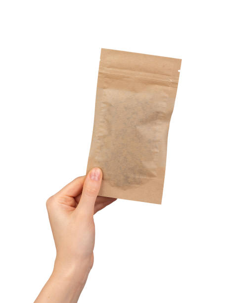 istock Hand holding small zip-lock kraft paper bag. Ziplock pouch, eco brown beige package 2117700619
