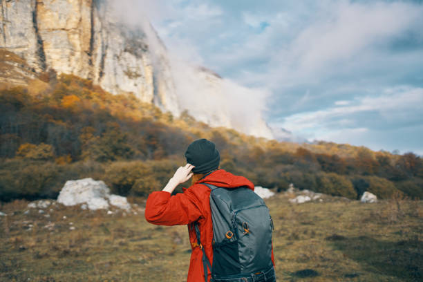 istock woman with a backpack red sweater warm hat landscape autumn fallen leaves model 2117709384