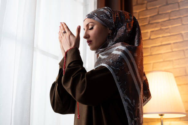 istock Muslim woman praying at home 2117714734