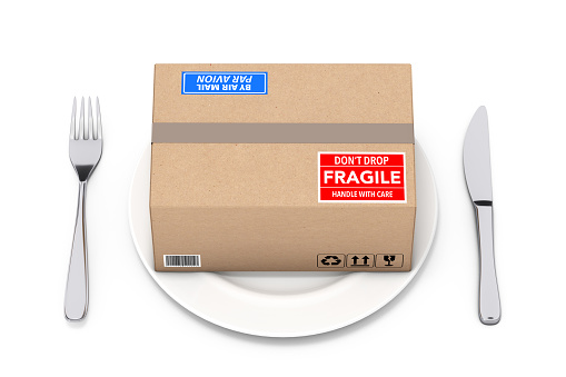 Cardboard Package and Parcel Box on Plate with a Fork and a Knife on a white background. 3d Rendering