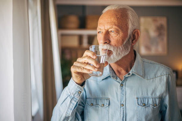 istock Senior man drinking a glass of water 2117779496
