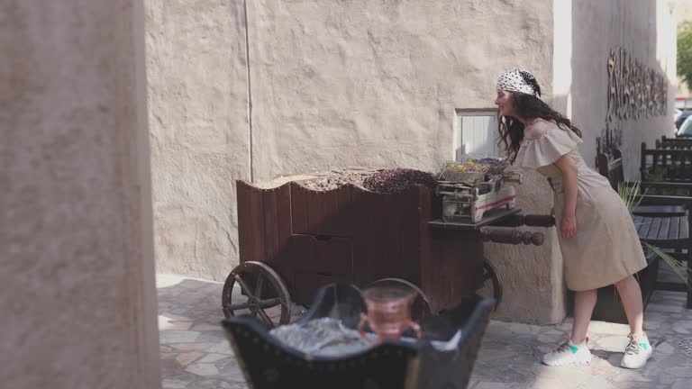 A woman smells some spices on a market stall