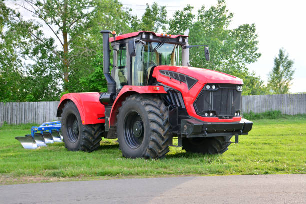 istock a red tractor with big wheels isolated on meadow close up 2117784759