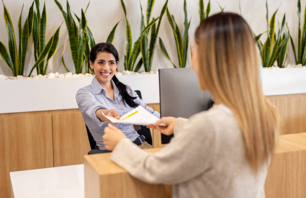 istock Happy receptionist working at an office and receiving some documents 2117819789