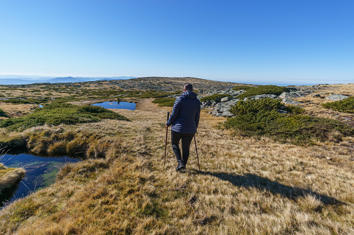 Hiking person in beautiful rocky landscape of high plateau of Torre with little vegetation on a sunny autumn day, Torre, Serra da Estrela, Portugal
