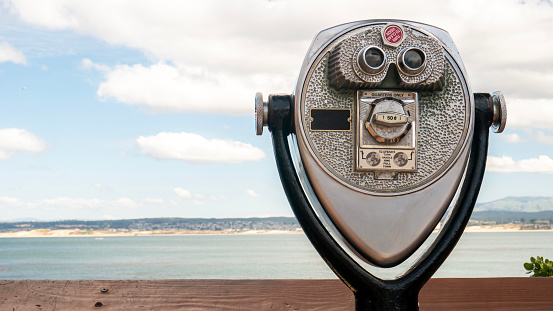 Coin-operated binoculars or observation viewer pointed at the sea, landmark viewer on a fun summer afternoon