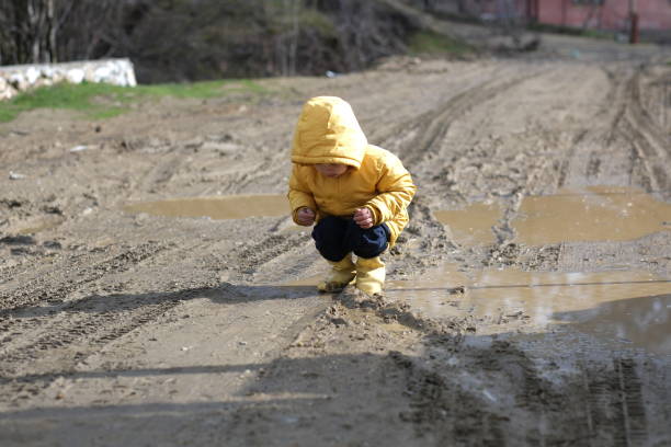 istock Little boy playing in mud water 2117902227