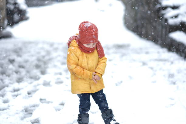 istock Cute childs are playing in snowfall 2117903443