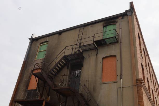 istock a ladder sitting on the side of a building that has boarded windows 2117922038