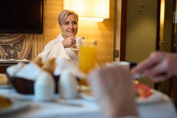 istock Woman drinking tea or coffee and looking at blurred cropped man having breakfast 2117925689