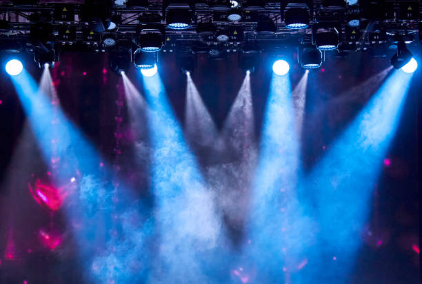 istock Bright stage spotlights shining through the smoke on a dark background 2117930964