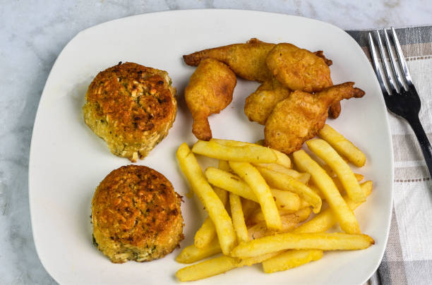 two crab cakes served with beer batter shrimp and french fries