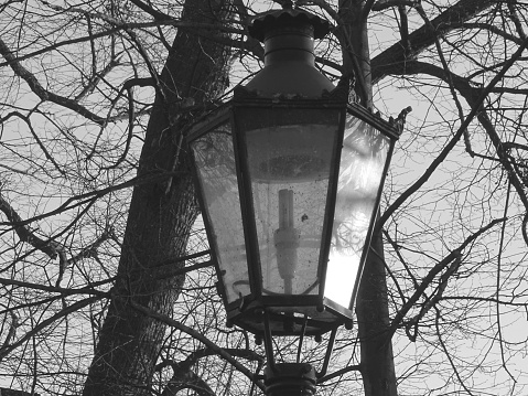 This photo was in mid December 2023, at a public park of Dusseldorf, Germany and depicts a vintage lantern reflecting the intense luminosity of the sunset