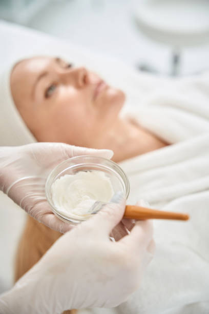 istock Qualified cosmetologist preparing white substance in little glass cup 2117974122