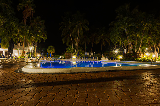 Miami Beach. USA. 03.27.2024. Beautiful nighttime ambiance surrounds the Radisson hotel, where palm trees sway beside an illuminated outdoor pool.