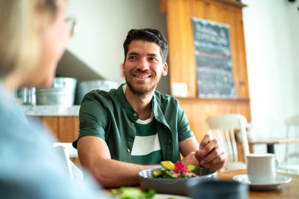 istock Young man talking with girlfriend at restaurant 2118007707