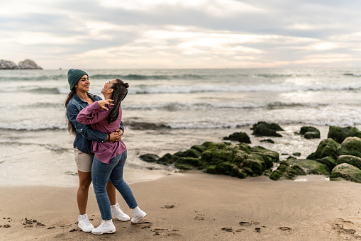 Lesbian couple dancing on the beach