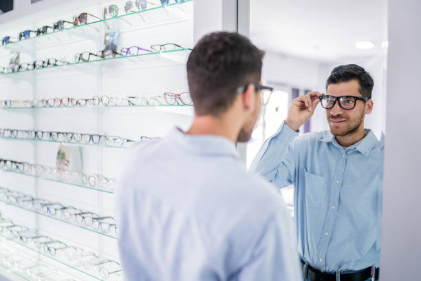 istock Young man buying a glasses at optical store 2118020533