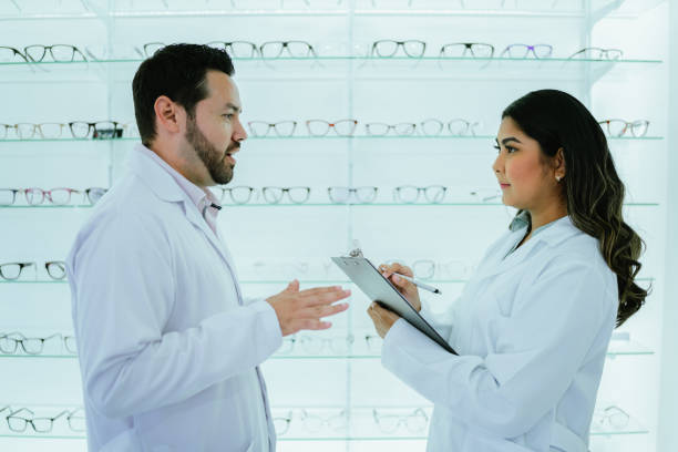 istock Opticians talking and writing on clipboard at optics 2118022416