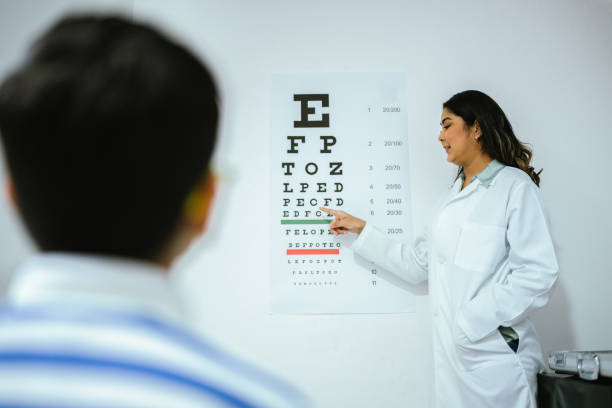 Child boy doing exam looking the eye chart at optics