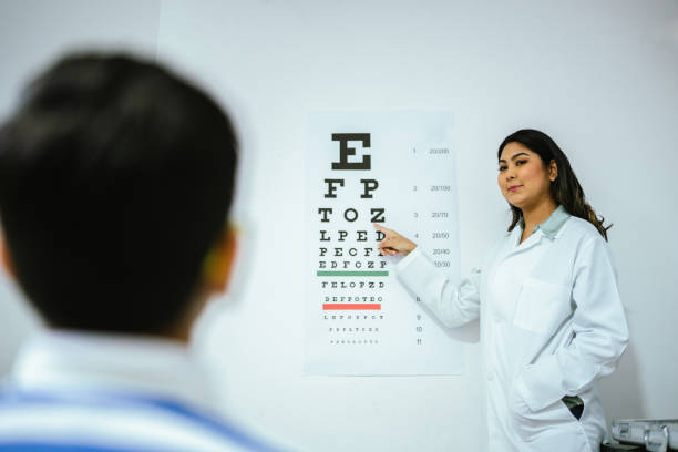 istock Child boy doing exam looking the eye chart at optics 2118023750