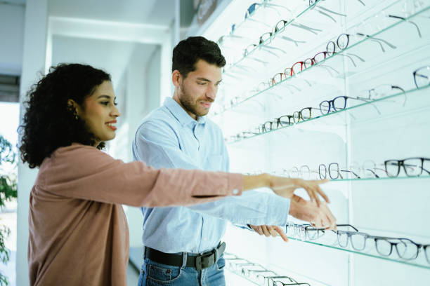 istock Young couple buying a glasses at optical store 2118028594