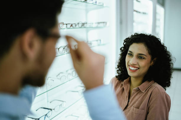 istock Young woman talking with boyfriend at optical store 2118032178