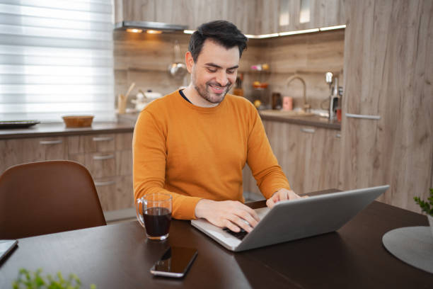 istock Caucasian man using laptop at home 2118047630