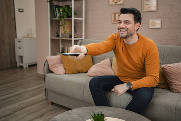 istock Man sitting on a sofa watching television 2118050240