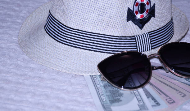 straw hat, dollar bills and sunglasses. some wardrobe items and necessary things during a summer holiday in the fresh air. protection of the head and eyes from the bright, scorching sun