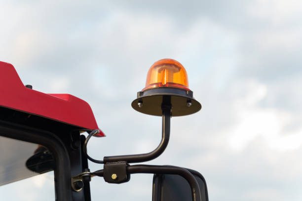 istock Orange Beacon Light on Farm Tractor Against Cloudy Sky 2118091476