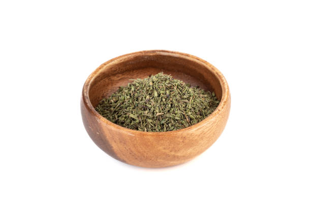 istock Dried thyme leaves in a bowl on white background. 2118100342