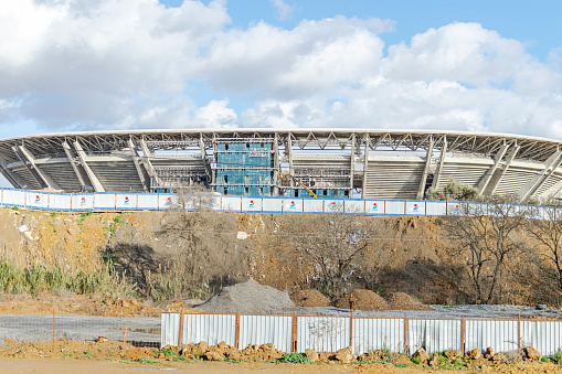 Algiers, Algeria- January 22, 2023: vue from the freeway on cheraga road. Cloudy blue sky, clear sunny day, trees and plants in dried soil Douera stadium of MCA