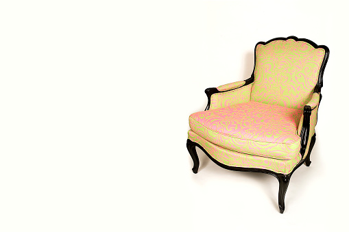 Vintage style armchair in yellow and pink color, retro furniture isolated on white background