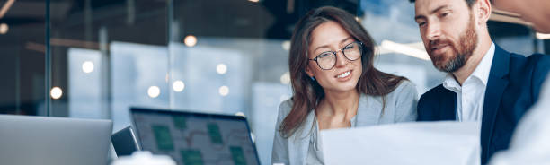close up of smiling businessmen discussing documents with graphs and charts in a modern office - panoramica immagine foto e immagini stock