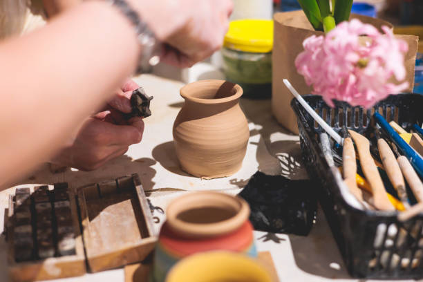 istock Pottery lesson master class for kids children, process of making clay pot on pottery wheel, potter hands creating ceramic crockery handcrafts, ceramist molding and painting jar or vase 2118132150