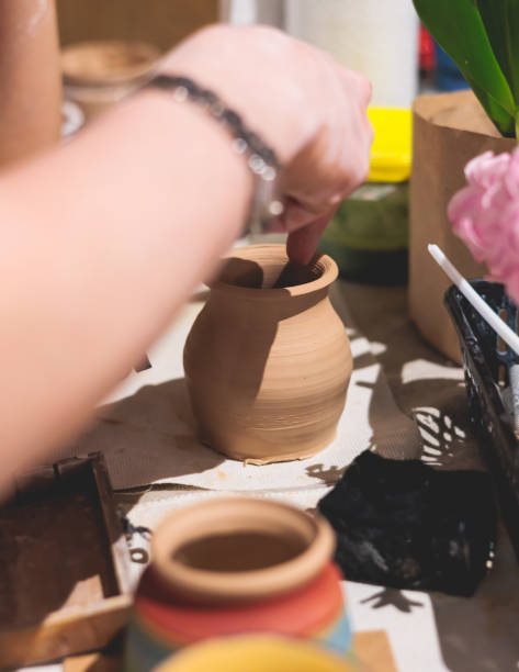 istock Pottery lesson master class for kids children, process of making clay pot on pottery wheel, potter hands creating ceramic crockery handcrafts, ceramist molding and painting jar or vase 2118132152