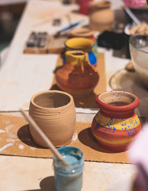 istock Pottery lesson master class for kids children, process of making clay pot on pottery wheel, potter hands creating ceramic crockery handcrafts, ceramist molding and painting jar or vase 2118133196