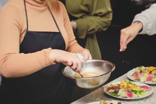 istock Group of people in a cooking class studio, adults preparing different dishes in the kitchen together, people in aprons learn on culinary master class, chef uniform, hands in gloves, italian cuisine 2118133720