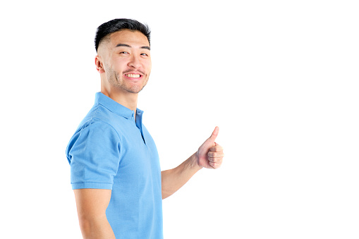 young oriental man smiling with blue polo shirt and thumb up on white background