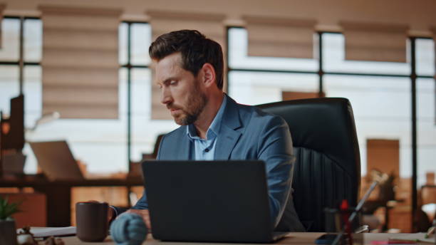 istock Focused manager checking work papers at workplace closeup. Man making coffee sip 2118203978