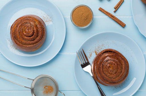 Sweet homemade cinnamon rolls on wooden background, top view