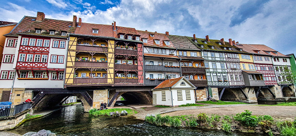 Erfurt, Germany - May 13, 2023: Merchants Bridge, Kraemerbruecke in Erfurt, Germany. It was built in 1325. The only bridge north of the Alps that is built over entirely with houses