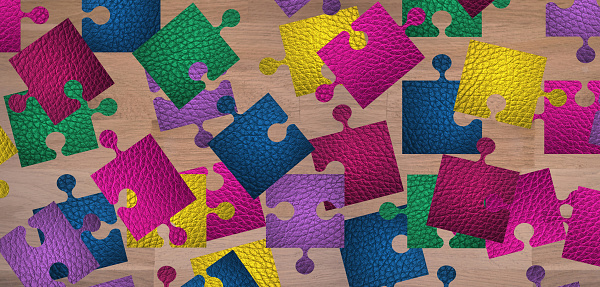 Multicolored leather puzzle placed loosely on a wooden table
